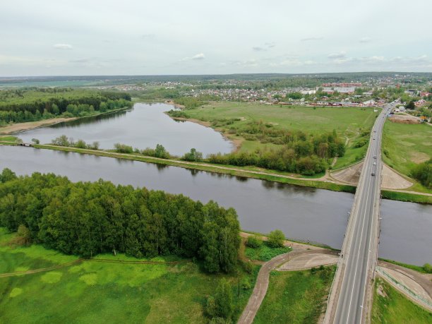 从桥的高度俯瞰河上美丽的全景景观。货轮在河上行驶的桥上的车辆交通。无人机上的照片图片下载