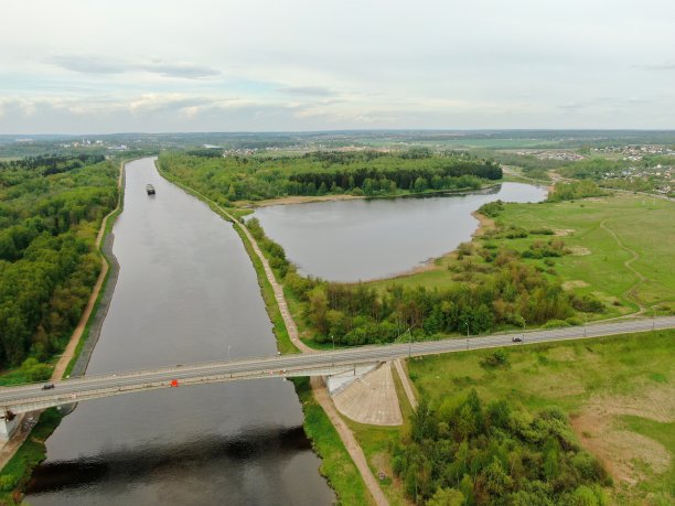 从桥的高度俯瞰河上美丽的全景景观。货轮在河上行驶的桥上的车辆交通。无人机上的照片图片下载