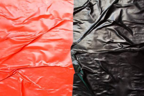 黑色和红色皱巴巴的光滑纸海报背景。图片下载