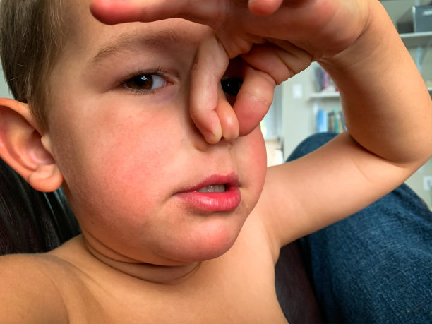 一个四岁的白人男孩拿着他的鼻子捏它之间的拇指和食指后闻到一些臭气图片下载