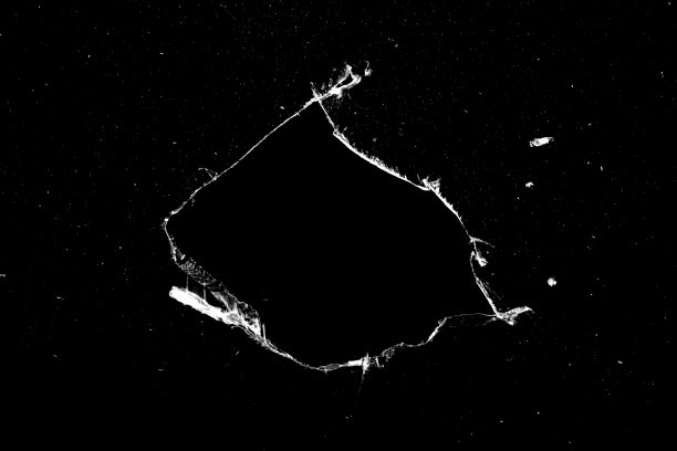 黑色背景上玻璃上的洞和裂缝。图片下载