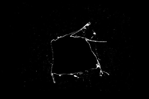 黑色背景上玻璃上的洞和裂缝。图片下载