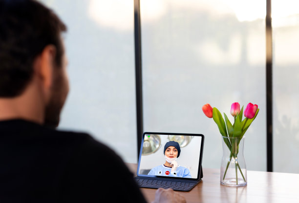 一名年轻人在隔离期间用笔记本电脑与妻子连接图片下载