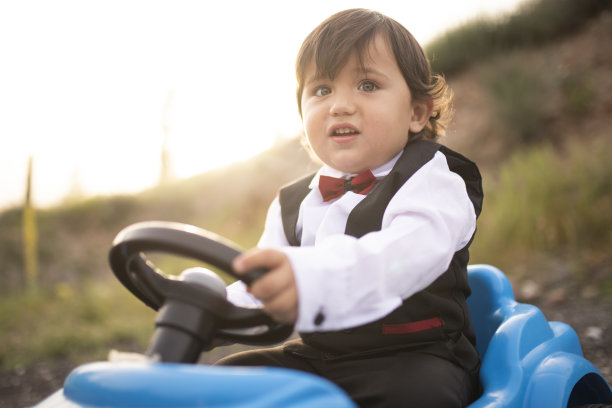 快乐的小男孩在公园里开着小车图片下载