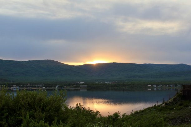 伟大的全景。一个干净的山湖在雄伟的山脉中间，在雾霾中。在日落图片下载