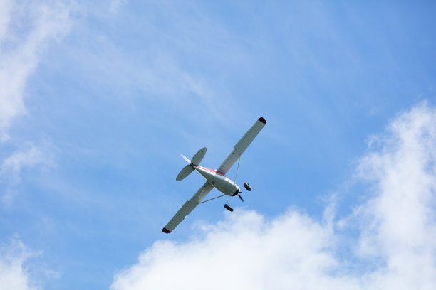 从地面观看一架小飞机在天空中飞行图片下载