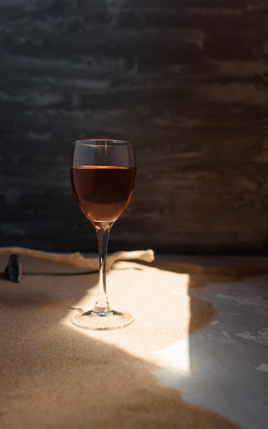 沙滩上的拱形阳光下，一杯红酒。图片下载