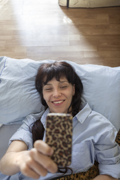 一个长发的黑人女孩躺在床上自拍图片下载