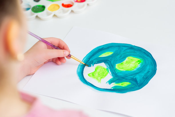 小女孩正在画地球。图片下载