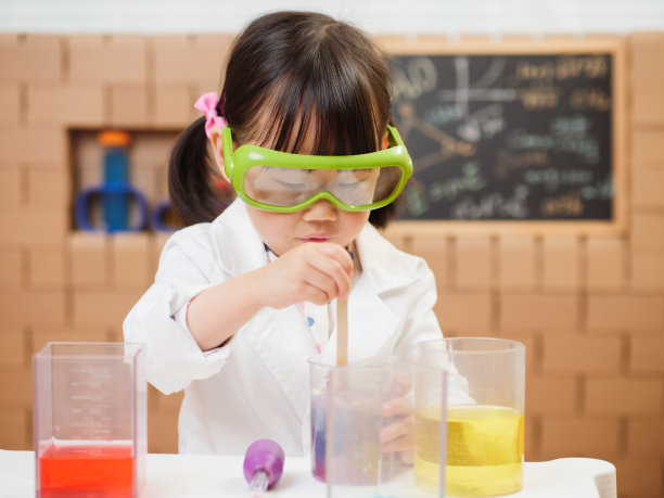 蹒跚学步的女孩假装扮演科学家角色在家上学图片下载