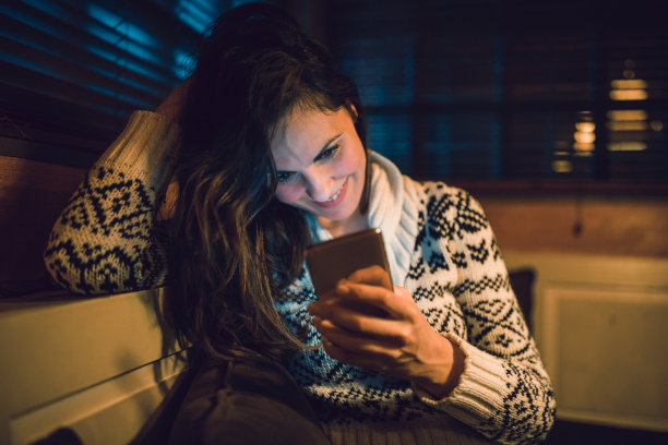年轻女子在晚上使用手机图片下载
