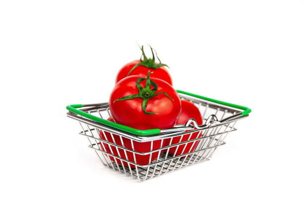 红色的三个新鲜番茄躺在杂货店的金属篮子里，背景是白色的图片下载