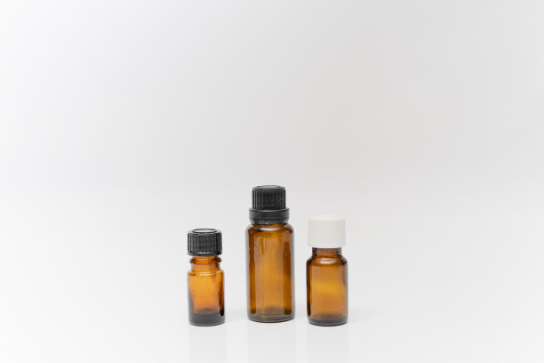香精油瓶容器棕色小香精油瓶与白色背景图片下载