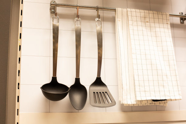 厨房里挂着的家用器具和绿色蔬菜。图片下载