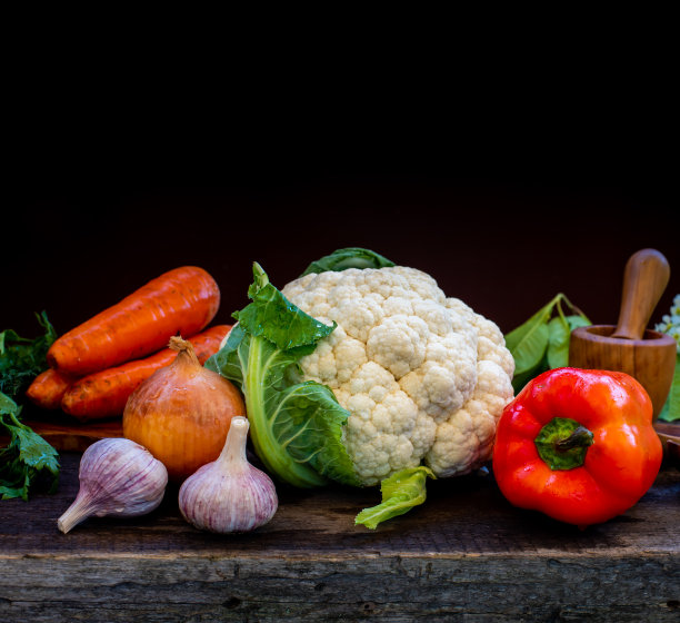 蔬菜，花椰菜，胡萝卜，大蒜，洋葱放在一张质朴的木头桌子上。图片下载