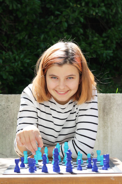 小女孩下棋，看着相机。图片下载