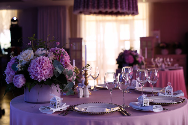 餐桌设置在一个粉红色的餐厅，节日晚餐，一束粉红色的花在桌子上，图片下载