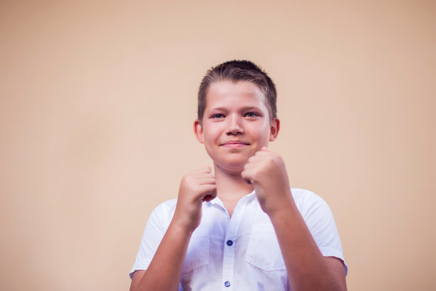 一个小男孩在镜头前展示拳头的肖像。童年与情感概念图片下载