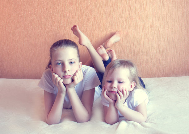 两个女孩坐在沙发上，拿着笔记本电脑图片下载