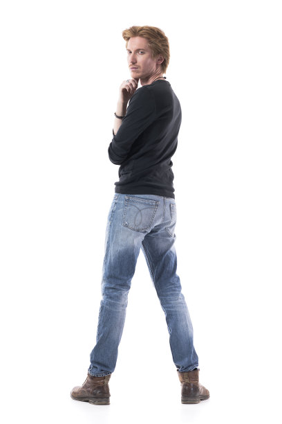 自信的年轻人转身看着镜头，手放在下巴图片下载
