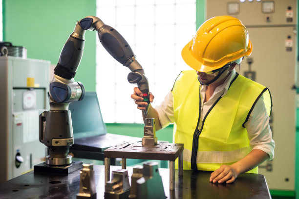 工厂检验员检查车床机器人手臂图片下载