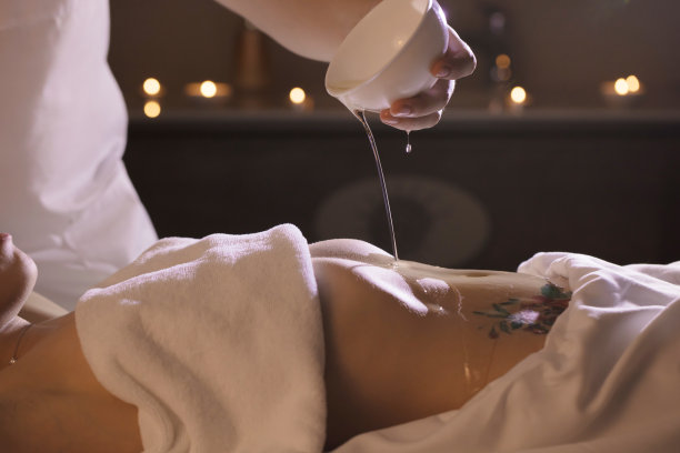 一个漂亮的女孩正在做健康手术，腹部涂着椰子油。图片下载