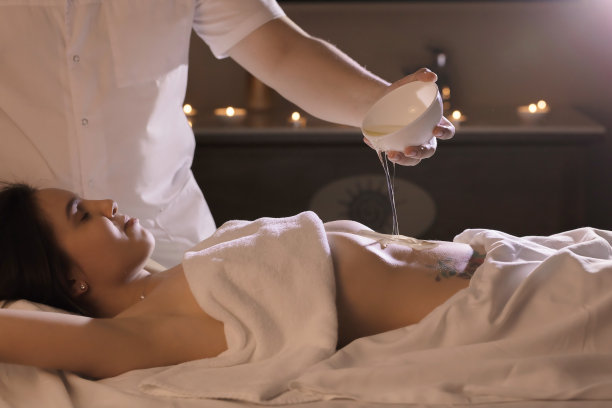 美丽的女孩用椰子油在胃上做健康手术图片下载