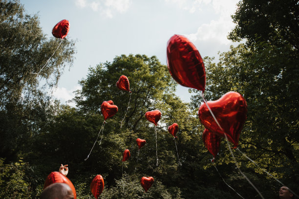 心形红色氦气球在天空中飞行的照片图片下载