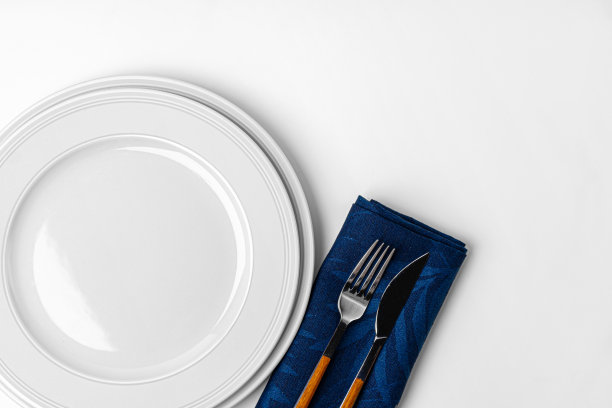 刀叉和盘子放在毛巾上。孤立在白色背景上。图片下载