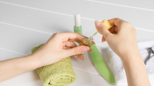 修指甲。一个女人在指甲上涂指甲油。保湿、护理、SPA、沙龙、护理、家居。化妆品、化妆品、卫生。自然的长指甲。未上漆的。法国修指甲。皮肤护理、美容图片下载