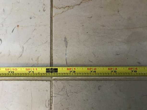 在瓷砖地板上用卷尺测量6英尺图片下载