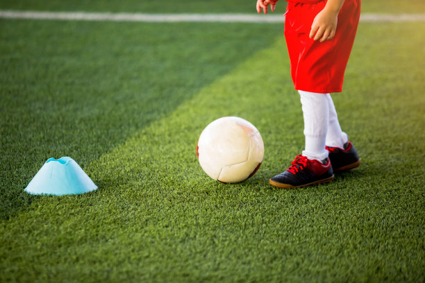 足球小孩用蓝色圆锥体标记控制球图片下载