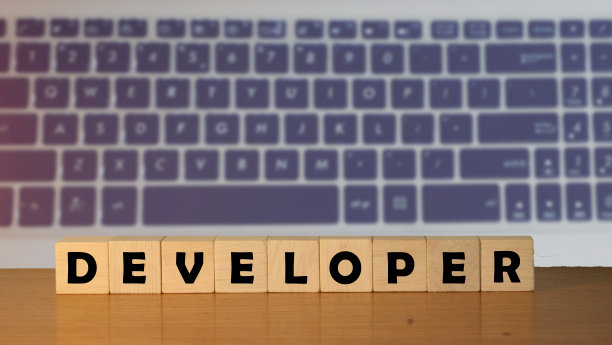 以绿色自然为背景的立方体木桌上的开发者留言图片下载