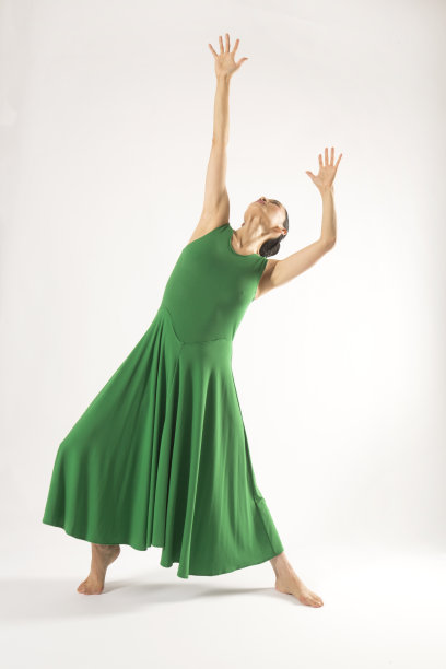 一个成年女子穿着绿色裙子在演播室跳舞。图片下载