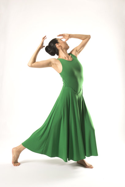 一个成年女子穿着绿色裙子在演播室跳舞。图片下载