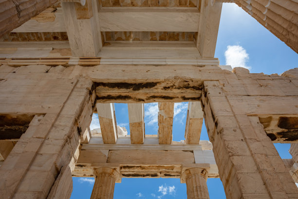 希腊雅典。在卫城的柱体上，纪念碑式的大门屋顶，蔚蓝多云的天空图片下载