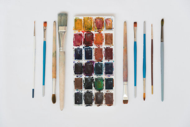 俯视图:在白色的表面是水彩颜料和各种画笔绘制。背景纹理。图片下载