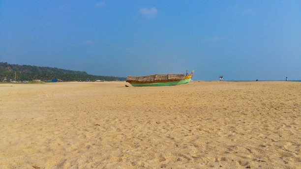 印度喀拉拉邦特里凡得鲁姆的阿齐马拉海滩的景观图片，一艘停泊在沙滩上的渔船。图片下载