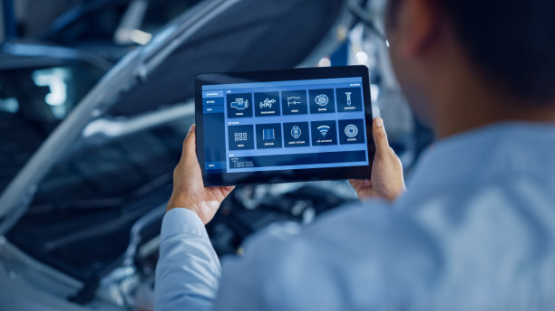 汽车服务经理或机械师使用平板电脑和未来交互式诊断软件。专家检查车辆，以便在发动机室找到损坏的部件。图片下载