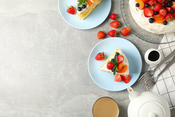 在灰色背景上搭配美味的浆果奶油蛋糕。美味的甜点图片下载