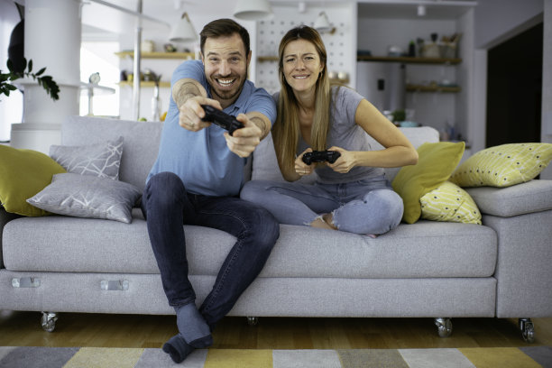 夫妻在客厅用游戏杆玩电子游戏图片下载