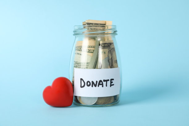 蓝色背景上有“捐赠”和“爱心”字样的玻璃罐图片下载