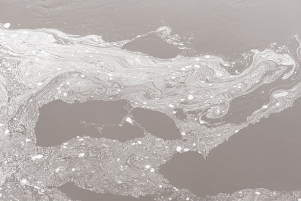 灰色背景上的白色图案是由河水污染造成的泡沫形成的图片下载