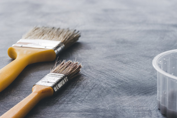 在灰色背景上使用画笔。材料油漆。图片下载