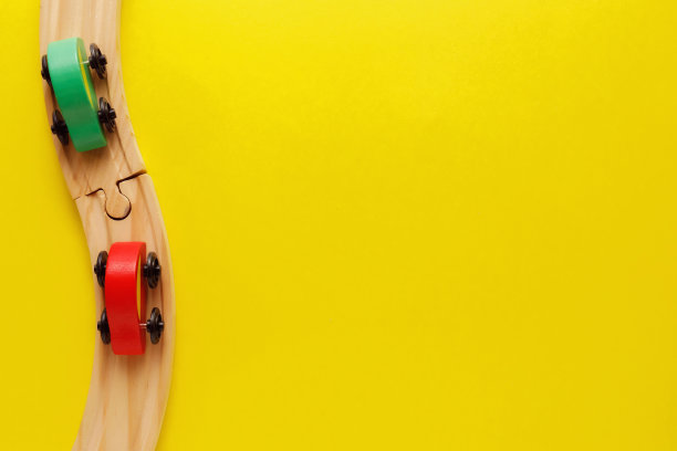 儿童玩具框架在黄色背景，玩具木制铁路和火车。前视图。Flatlay。文本复制空间图片下载