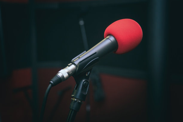 录音室里的麦克风放在一个支架上，背景是黑色的图片下载