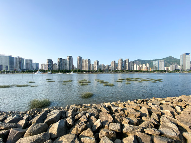 一个现代城市的天际线与石头河海滩图片下载