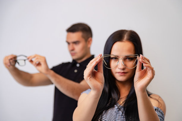 一对可爱的笑眯眯的情侣，透过眼镜看眼镜。图片下载