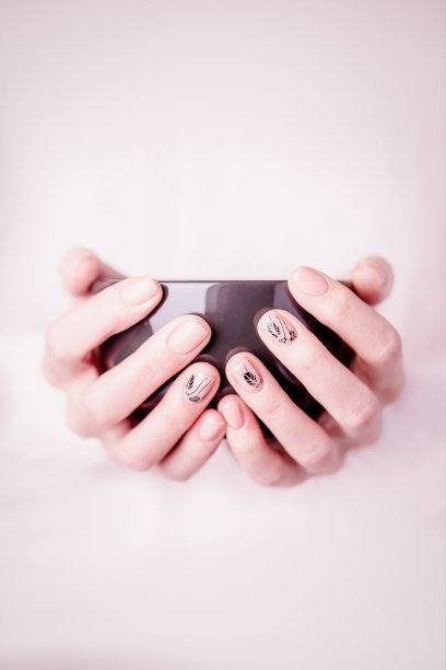 美丽的女性手握着黑色的杯子在粉红色的背景图片下载