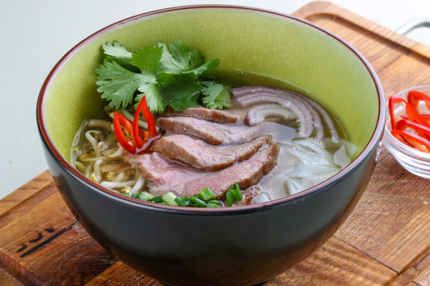 亚洲辣汤配小牛肉放在木板上。在白色背景上。图片下载